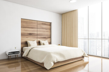 Bed and linens in wooden bedroom with parquet and window