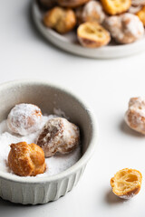 Bunuelos, Small  deep fried doughs in ceramic ball  with sugar on white background..
