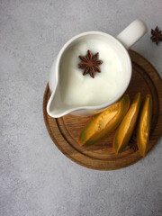 Fototapeta na wymiar milk with anise and pumpkin on a wooden cutting board