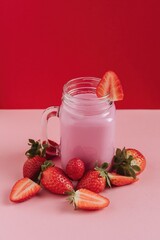 Batido de fresa rodeado de fresas cortadas.