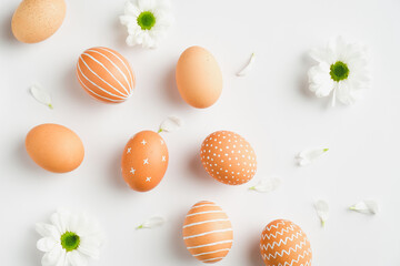 Happy Easter minimal concept. Flat lay, top view Easter eggs and spring flowers on white background.