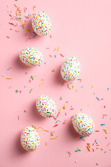 Fototapeta na wymiar Colorful easter eggs decorated sweets on pink background. Flat lay, top view, vertical