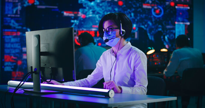 Woman working in high tech security center during pandemic