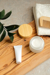 Haircare beauty products set and green leaf on wooden board on bathroom table. Natural organic cosmetics concept