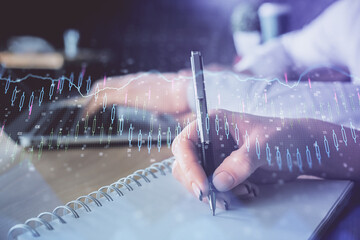 Double exposure of forex chart drawing over people taking notes background. Concept of financial analysis