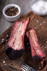 Barbecue beef smoked ribs with coarse sea salt and black pepper on a wooden Board.