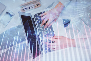 Obraz premium Double exposure of woman hands working on computer and forex graph hologram drawing. Top View. Financial analysis concept.