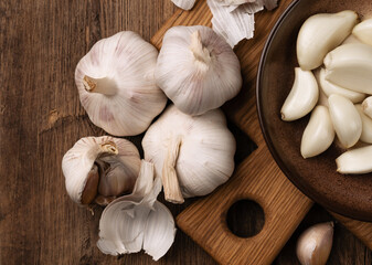 heads of garlic close-up on a kitchen board on a wooden table.