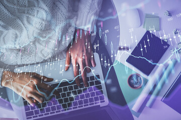 Multi exposure of woman hands working on computer and forex chart hologram drawing. Top View. Financial analysis concept.