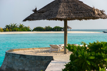 deck chairs in lounge zone on the beach at tropical island with ocean view 