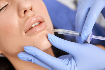 Naklejka premium Professional cosmetologist is doing procedures for client in light cabinet