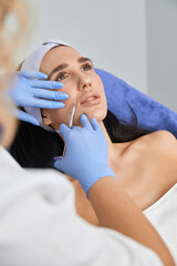 Professional cosmetologist is doing procedures for client in light cabinet