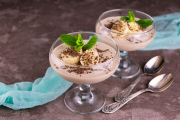 Banana dessert decorated with mint on a gray background.