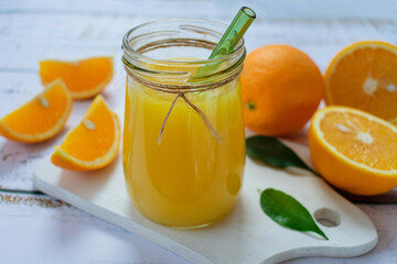 Orange juice in a jar on a light background.
Close-up.