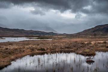 Epic dramatic landscape image of Loch Ba on Rannoch Moor in Scottish Highlands on a Winter morning