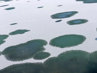 The freezing of the waters of the pond and creating magnificent views with the falling snow and the melting texture of the ice