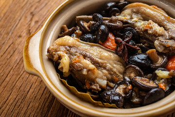 Lamb chops stewed with delicious mushrooms in a clay pot on a wooden table