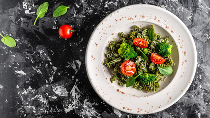 penne pasta with spinach with cherry tomatoes. proper diet. Long banner format, top view