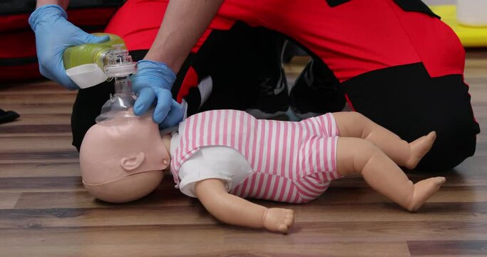Giving first aid on a child dummy. Practitioners training medical learning on a baby mannequin. Emergency course for resuscitation. First aid training.