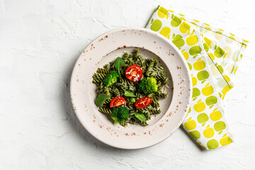 Fresh homemade green penne pasta with vegan pesto and cherry tomatoes on light background. banner, menu recipe place for text, top view