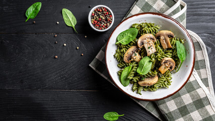 vegetarian dish green penne pasta with spinach and mushrooms. Healthy vegan food. banner, menu recipe place for text, top view