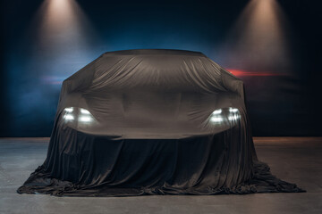 Presentation of the car. Car under the tissue at the autoshow. Brand new car waiting after show and...