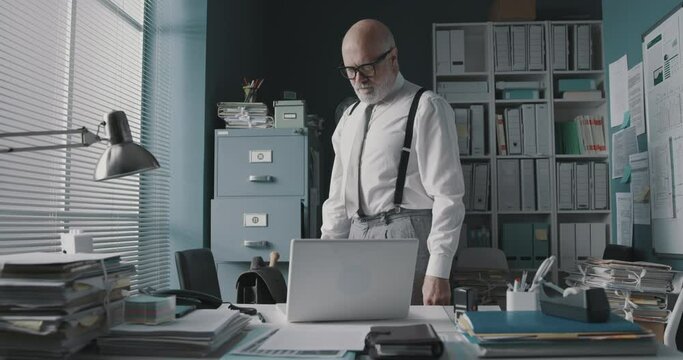 Angry businessman destroying his laptop