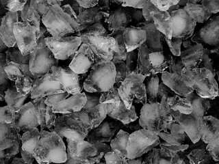 Texture, pattern, or wallpaper. Clean, white crushed (chipped) ice cubes on a black studio contrasting background.