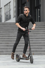 Young man riding electric scooter in urban background
