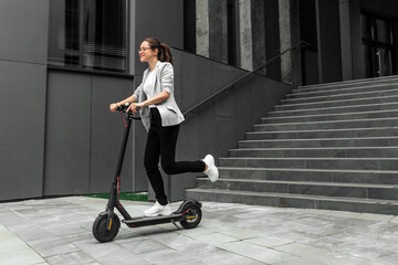 Young woman riding electric scooter in urban background © Oleksandr Kozak