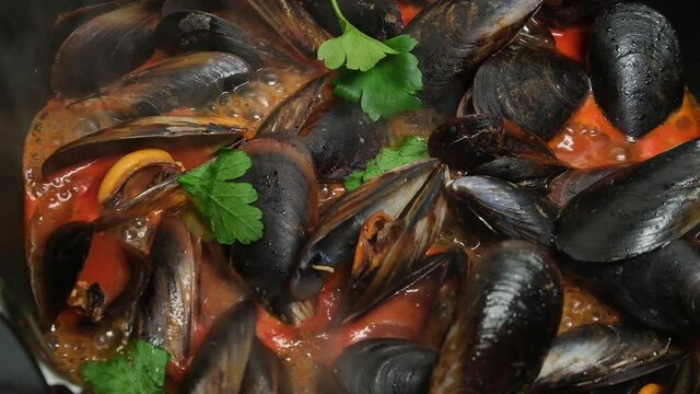 Mussel soup, close-up seafood mussels in tomato sauce cooking