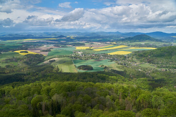 Picturesque aerial view on small czech village and green forest as foreground with clouds and blue sky