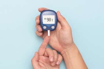 Man using glucometer, checking blood sugar level