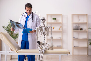 Young male doctor radiologist and skeleton patient in the clinic