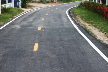 black asphalt winding road transport with white and yellow line