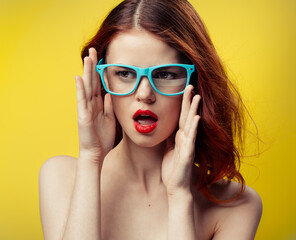 attractive woman with bare shoulders red lips blue glasses close-up