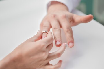 The bride puts her wedding ring on her groom's finger. High quality photo