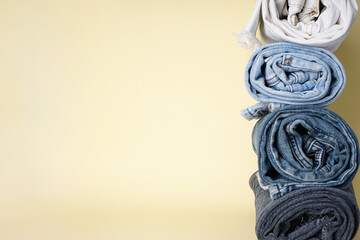Folded jeans on a yellow background, place for text.
