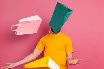 Happy bearded positive man casual look with colorful shopping bags studio pink background