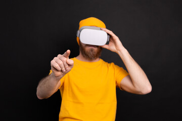 Handsome positive bearded man touching air in vr glasses studio background