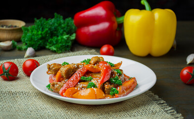 Hot vegetable salad with chicken, zucchini and pepper, sprinkled with sesame seeds and herbs on a wooden table. Asian food. Side view.