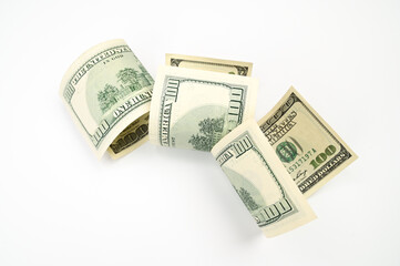 one hundred dollar bills rolled up, on an isolated white background