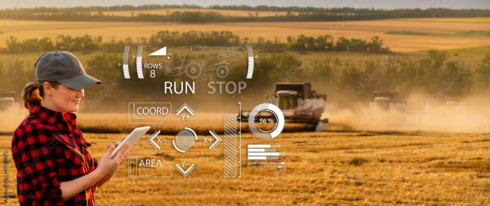 Fototapete remote control of an autonomous combine in the field. farmer with a digital tablet in the agricultur