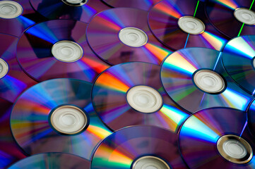 Background CD and DVD discs laid out on a flat surface. Background for saving information. Abstraction.