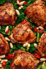 One-pot braised chicken thighs with kale and cannellini beans served with chili peppers