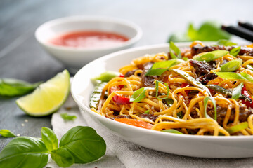Stir fry noodles with beef and vegetable in white bowl. asian style food