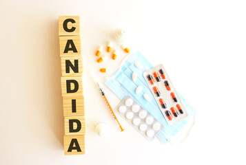 The word CANDIDA is made of wooden cubes on a white background. Medical concept.