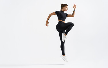 Dynamic movement of young and healthy sports woman doing jump exercising in sportswear. Fitness...
