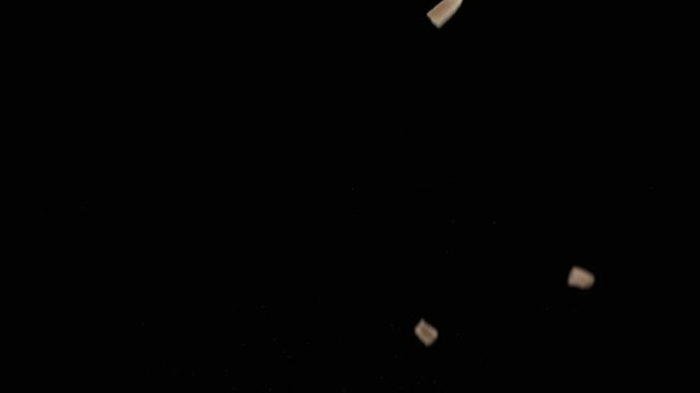 Flying up coconut chips on the black background. Slow motion