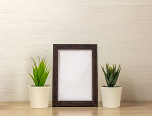 An empty wooden photo frame on a table or shelf with a copy of the space.